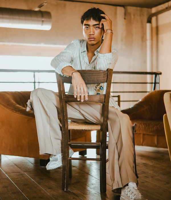 Woman in a calm pose against a dark background with cyan light.